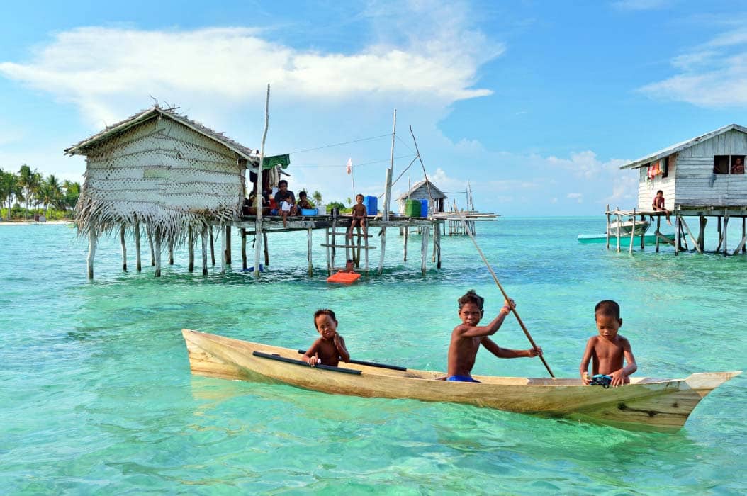 Stilt village walkway with children and drying laundry